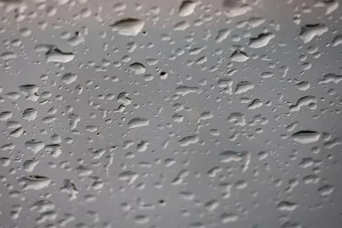 Close-up view of water droplets on a smooth gray surface, creating abstract.. Stock Photos