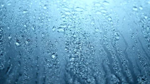Close up view of water drops falling on glass. Rain running down on window. R Stock-Footage 107209613