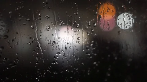 Close up view of water drops falling on glass at night. Colorful traffic bokeh Stock Footage 125154093