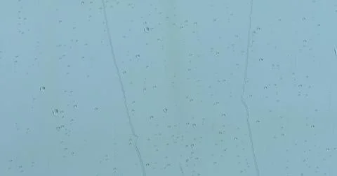 Close up view of water drops falling on window glass. Rain running down. Stock Photos