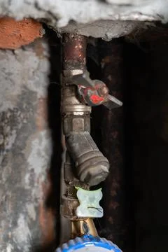 A close-up view of a water meter installed on an old plumbing pipe inside a Stock Photos