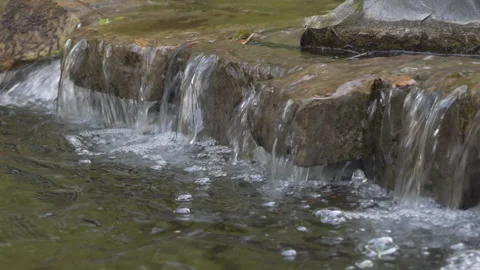 A close up view of a water steaming over stones. Stock Footage 137465161