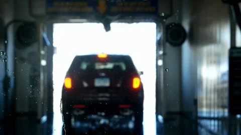 Close view of water on windshield and car leaving a car wash. Stock Footage 104987257