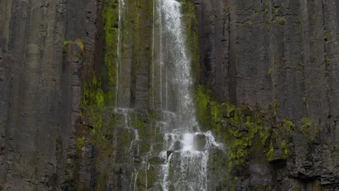 Close Up View of Waterfall Cascading Down Icelandic Basalt Column Rock Formation Stock Footage 339875086