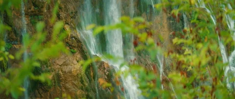 Close-up view of a waterfall through foliage at Plitvice Lakes National Park Video stock 311960698
