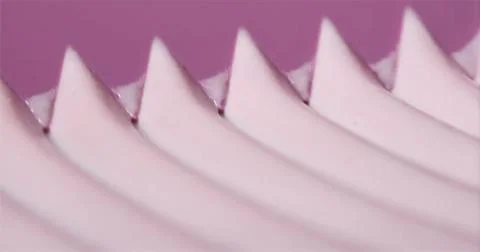 Close view of a wavy pink surface with sharp peaks created by a textured ob.. Stockfoto's