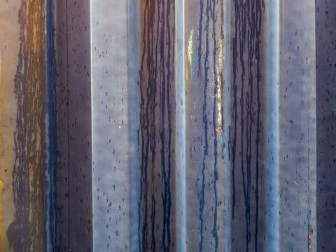 A close-up view of a weathered blue corrugated metal surface, featuring promi Stock Photos