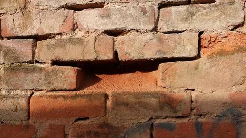 Close-up View of a Weathered Brick Wall Showcasing Texture and Color Variatio Foto stock