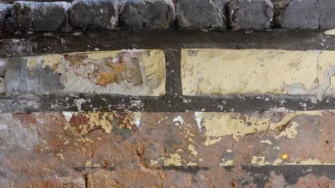 A Close-Up View of a Weathered Brick Wall With Peeling Paint and Textures Stock Photos