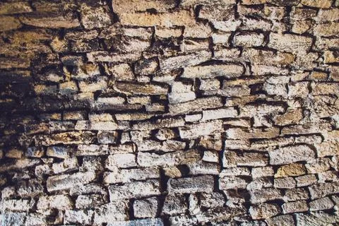 A close-up view of a weathered brick wall highlights the unique textures and Stock Photos