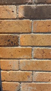Close-up view of a weathered brick wall with varying shades of brown and or.. Stock Photos