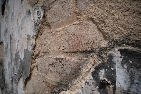 Close up view of weathered brick wall and peeling plaster 스톡 사진