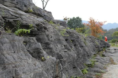 Close-up view of weathered, layered gray rock formations along a stone path Stock Photos