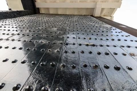 A close-up view of a weathered metal surface with riveted plates arranged i.. Stock Photos