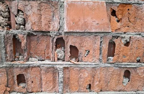 Close up view of a weathered red brick wall with erosion and crumbling sect.. Stock-Fotos