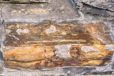 Close-up view of weathered sandstone layers with rich earthy tones and text.. Stock Photos
