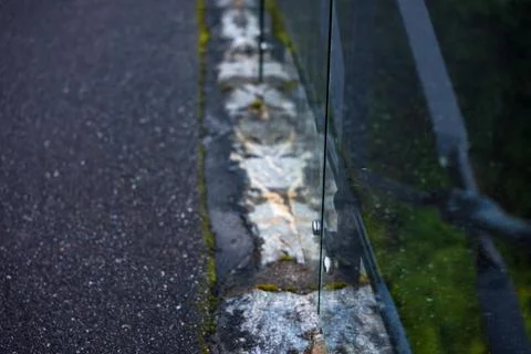 Close-up view of weathered stone barrier with moss and asphalt road, Norway Stock-Fotos