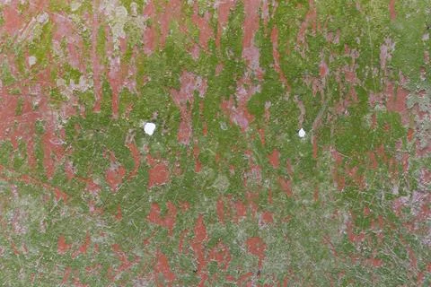 A close-up view of a weathered surface with green and red paint peeling off Stock-Fotos