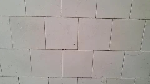 Close up view of weathered white square ceramic wall tiles Stock Photos