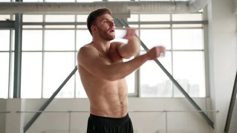 Close-up view of a weightlifter performing exercises in a gym alone Stock Footage 227613204