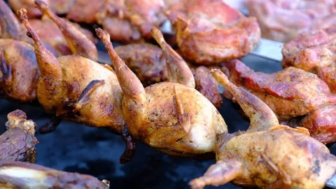 A close view of well-cooked quail meat on skewers, lying on a brazier Stock Footage 91746365
