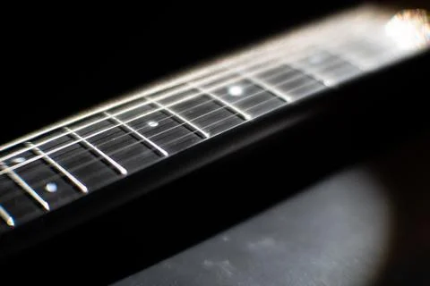 Close-up view of a well-maintained guitar neck and fretboard, with strings ru Stock Photos