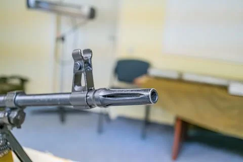 Close-up view of a well-maintained rifle muzzle on a wooden surface, with a.. Foto stock