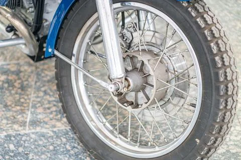 Close-up view of a well-maintained vintage motorcycle front wheel with text.. Stock Photos