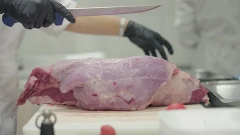 Close-up view when a butcher slicing fresh meat with his hands and sharpen Stock Footage 297660253