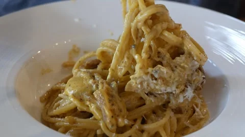 Close up view while usinng fork and spoon to eat italian carbonara spagetth.. Stock Footage 282335659