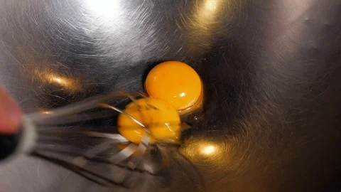 Close up view of whipped eggs in glass bowl, electric whisk and broken empty egg Stock Footage 119157540