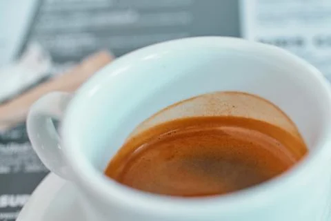 Close-up view of a white ceramic cup filled with fresh espresso coffee with.. Stock Photos