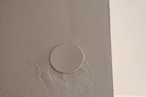 Close-up view of a white circular patch on textured wall, showcasing minimalist 写真素材