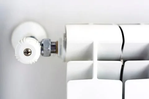 Close-up view of the white knob that adjusts the temperature of the radiator Stock Photos
