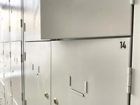 Close-up view of white metal lockers with number 14 visible, showcasing a row of Stock Photos