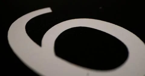 Close-up view of a white number on a black background showing the shape and text Stock Photos