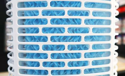 Close-up view of a white plastic air cooler grill with blue cooling pad mes.. Stock Photos