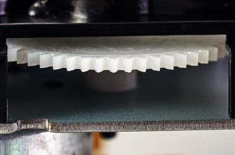 Close-up view of a white plastic gear mechanism with interlocking teeth Stock Photos