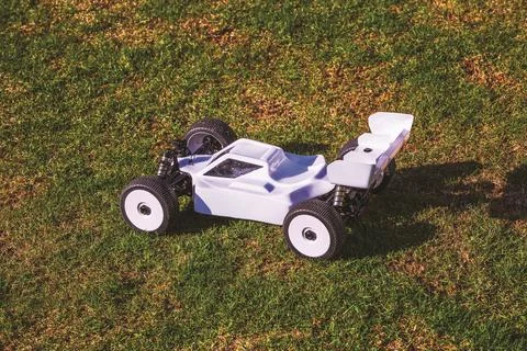 Close-up view of white remote control off-road buggy on grass lawn Stock Photos
