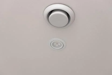 Close up view of white round ceiling vent. Building construction elements. Stock Photos