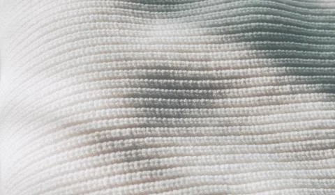 Close up view of white sweater texture with sunlight Stock Photos