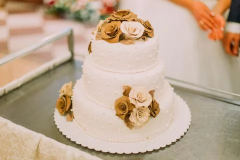 The close-up view of the white three-floor wedding cake decorated with chocolade Stock Photos
