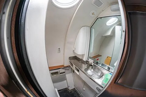 Close-up view of a white, utilitarian airplane interior through a slightly cu Stock Photos