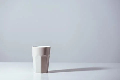 Close-up view of white vase with shadow on grey 库存照片