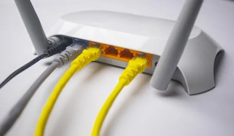 Close-up view of a white wireless router back panel with two yellow Etherne.. Stock Photos