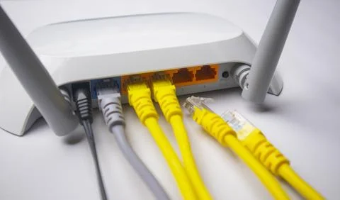 Close-up view of a white wireless router back panel with multiple connected.. Stock Photos