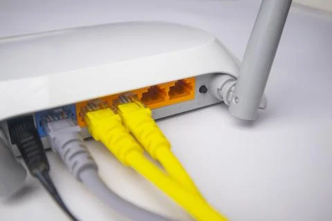 Close-up view of a white wireless router back panel with two yellow Etherne.. Stock Photos