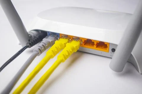 Close-up view of a white wireless router back panel with two yellow Etherne.. Stock Photos