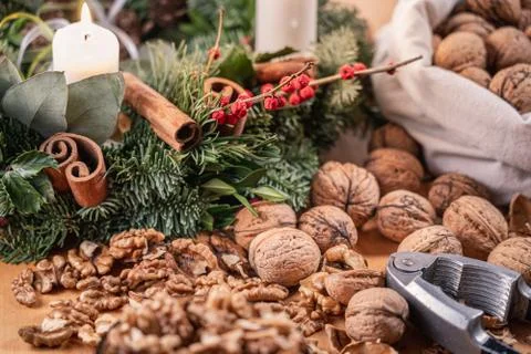 Close up view of whole walnuts, a nutcracker and scattered nuts and shells on Stock Photos