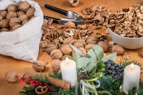 Close up view of whole walnuts, a nutcracker and scattered nuts and shells on Stock Photos